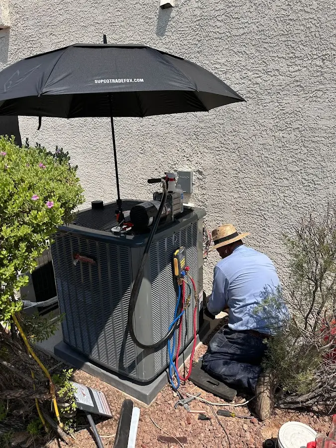 HVAC technician performing outdoor AC maintenance in Derry